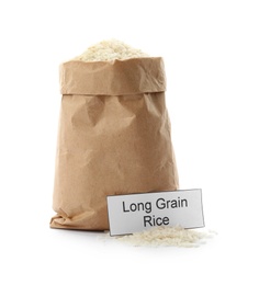 Photo of Paper bag with uncooked long grain rice and card on white background