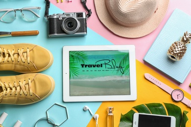 Photo of Flat lay composition with tablet and travel blogger's stuff on color background