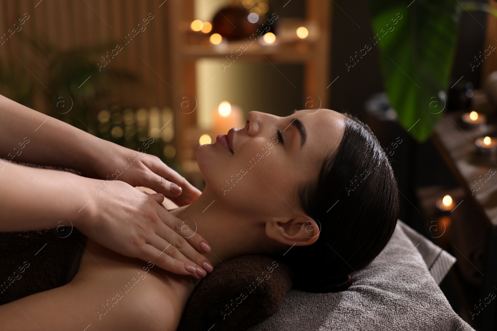 Photo of Spa therapy. Beautiful young woman lying on table during massage in salon