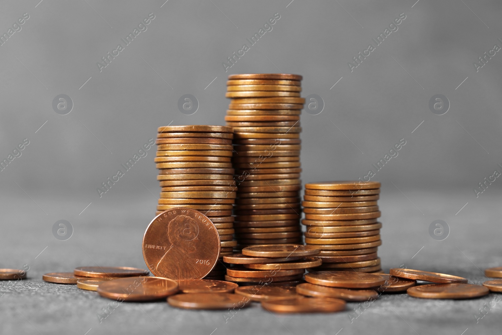 Photo of Stacks of coins on table against color background