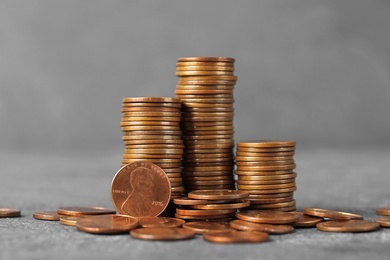 Stacks of coins on table against color background