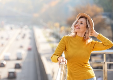 Portrait of happy mature woman on balcony, outdoors