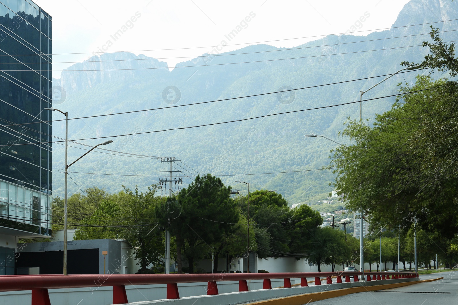 Photo of Modern road with cars in city near mountains