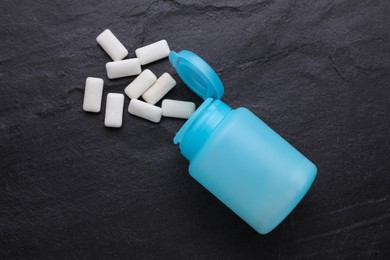 Photo of Jar with chewing gums on black table, flat lay