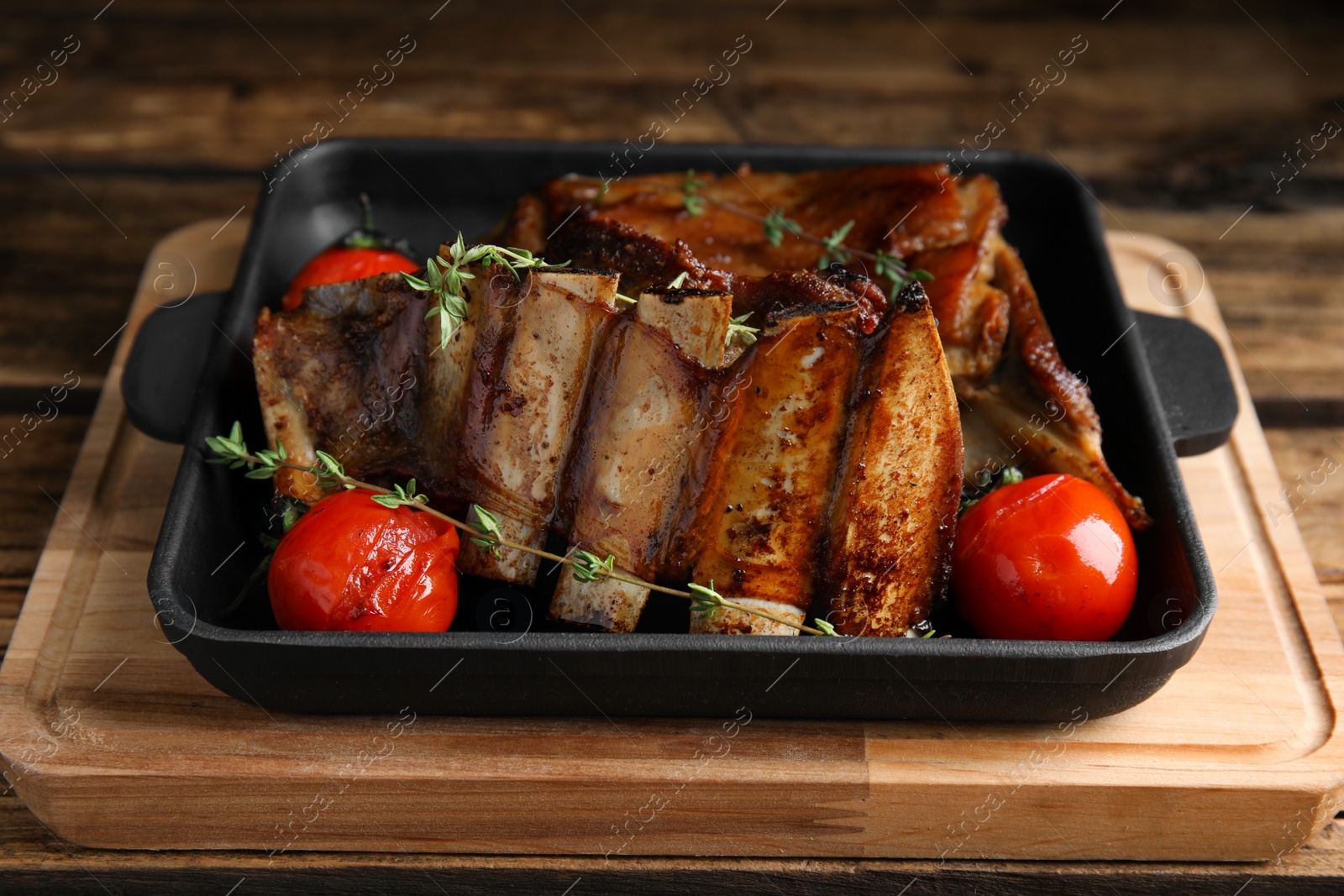 Photo of Delicious roasted ribs served on wooden table