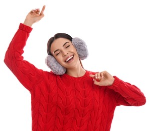 Beautiful young woman wearing earmuffs on white background