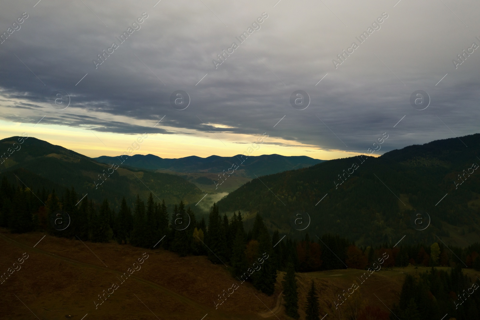 Image of Aerial view of beautiful mountain landscape with forest on cloudy day