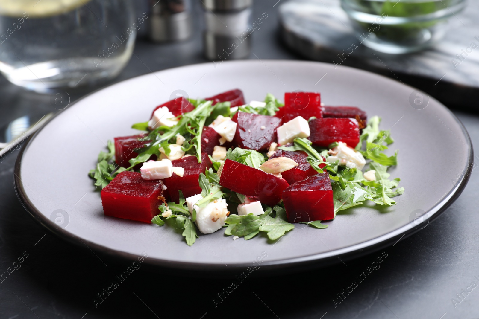 Photo of Delicious beet salad served on black table, closeup