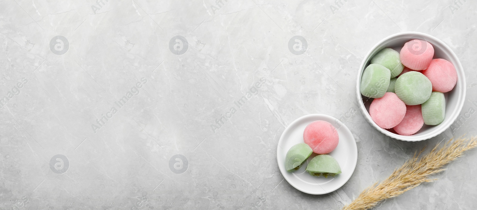 Photo of Delicious mochi and pampas grass on light grey marble table, flat lay with space for text. Traditional Japanese dessert