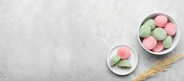 Photo of Delicious mochi and pampas grass on light grey marble table, flat lay with space for text. Traditional Japanese dessert