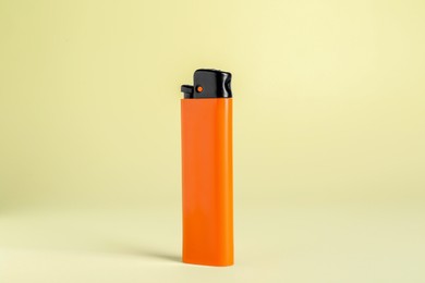 Photo of Stylish small pocket lighter on beige background