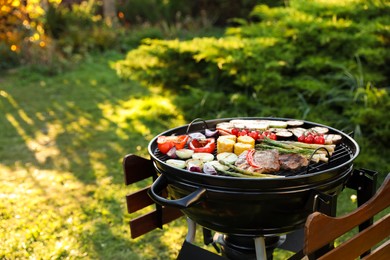 Photo of Delicious grilled vegetables and meat on barbecue grill outdoors