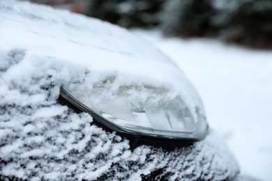 Photo of Modern car covered with snow outdoors on winter day, closeup. Frosty weather