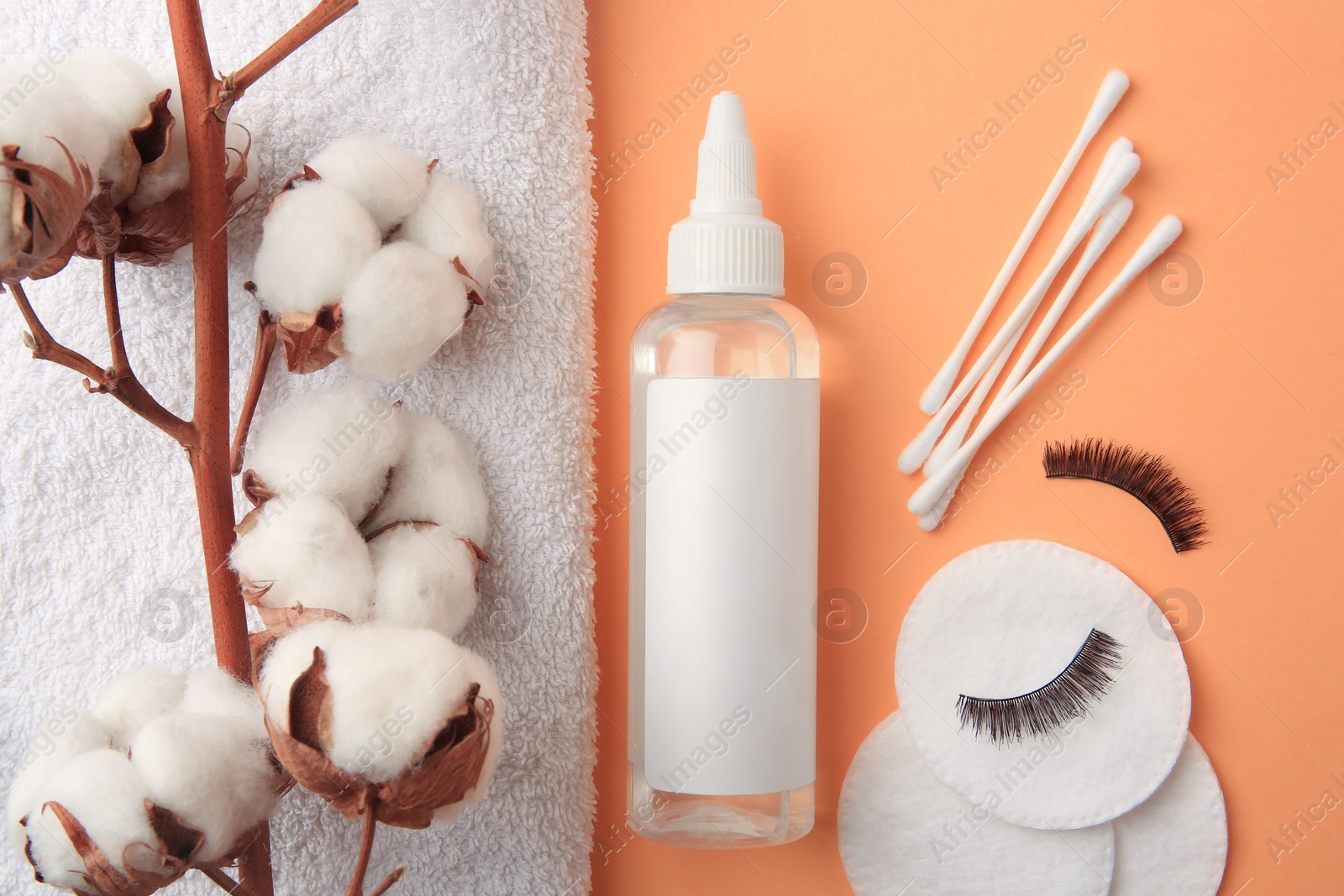 Photo of Flat lay composition with makeup remover and cotton flowers on pale orange background