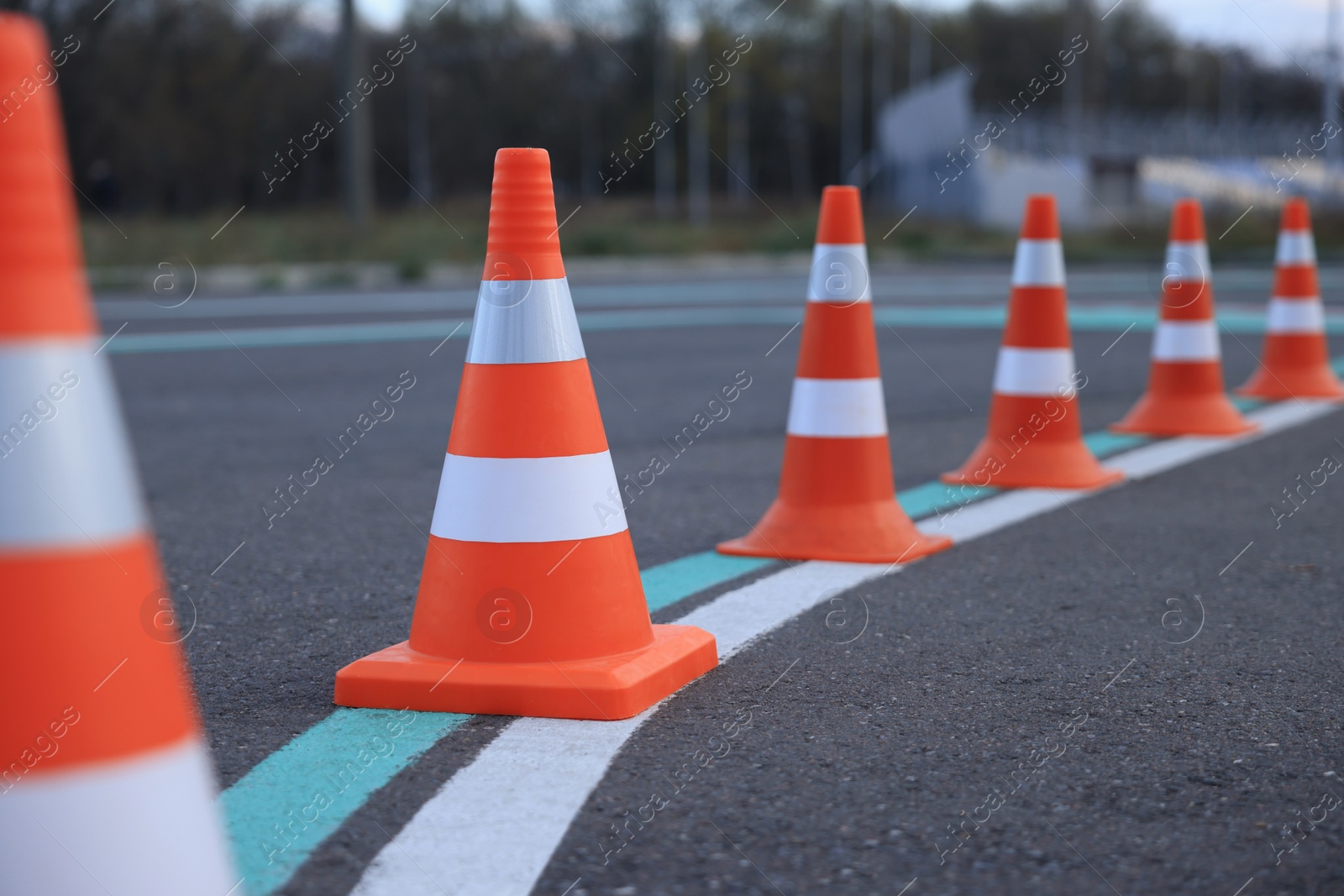 Photo of Driving school test track with marking lines, focus on traffic cone