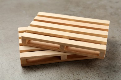 Photo of Two small wooden pallets on light grey table