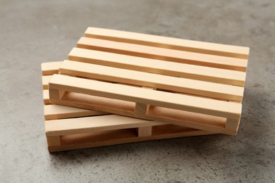 Two small wooden pallets on light grey table