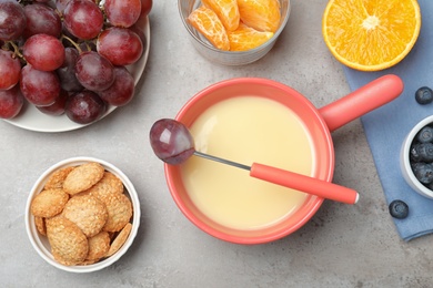 Flat lay composition with white chocolate fondue on grey stone background