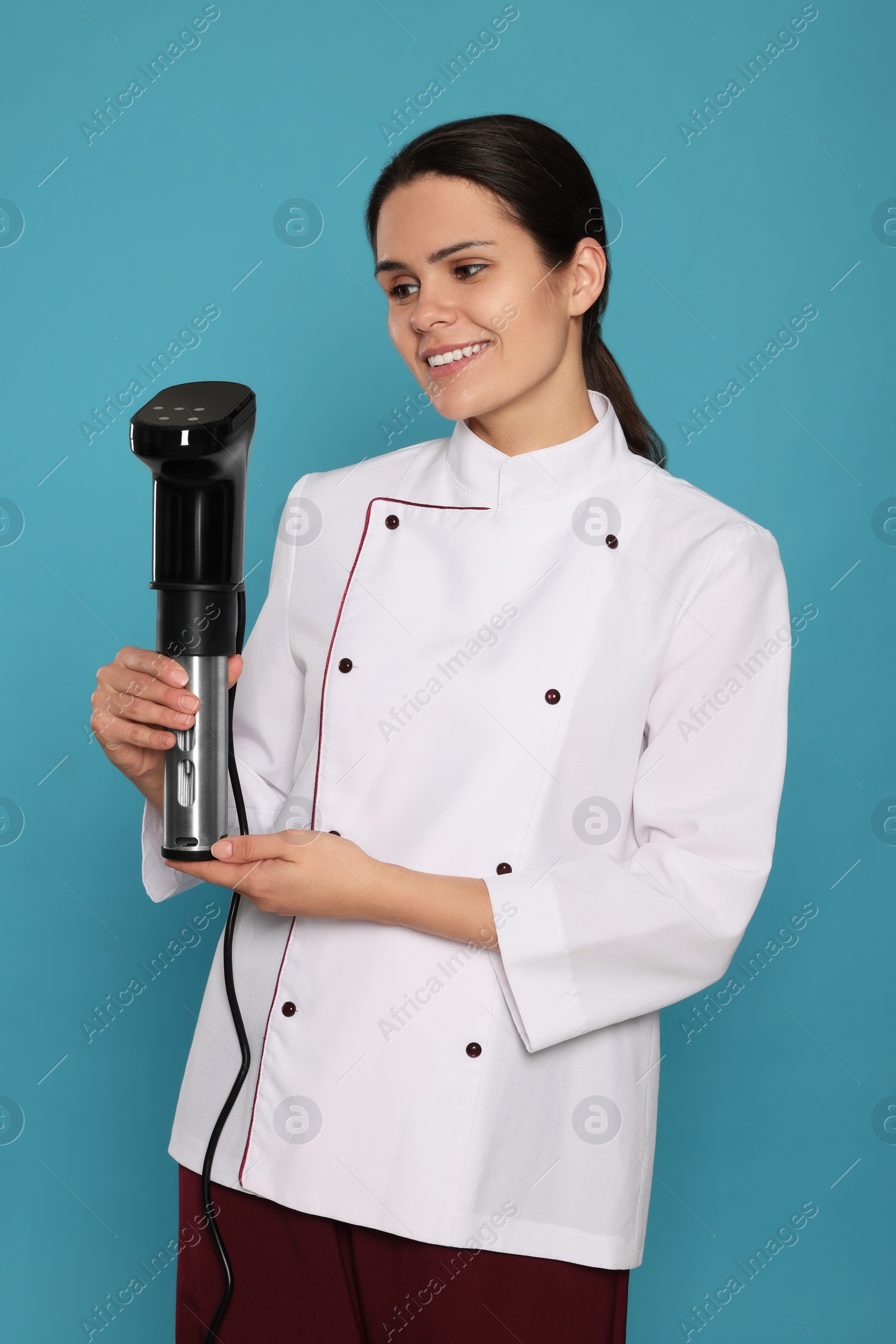 Photo of Chef holding sous vide cooker on light blue background