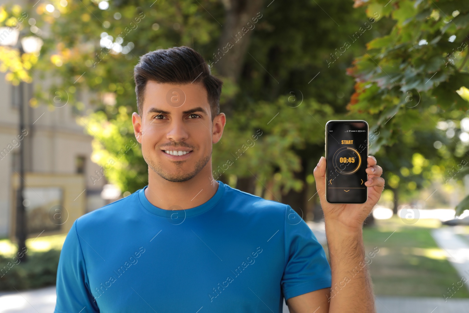 Photo of Man showing smartphone with fitness app on city street
