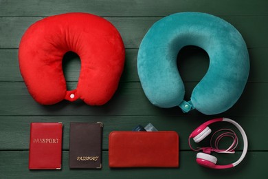 Photo of Flat lay composition with colorful travel pillows on green wooden background