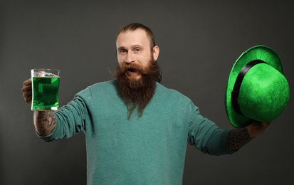 Photo of Bearded man with green beer on grey background. St. Patrick's Day celebration