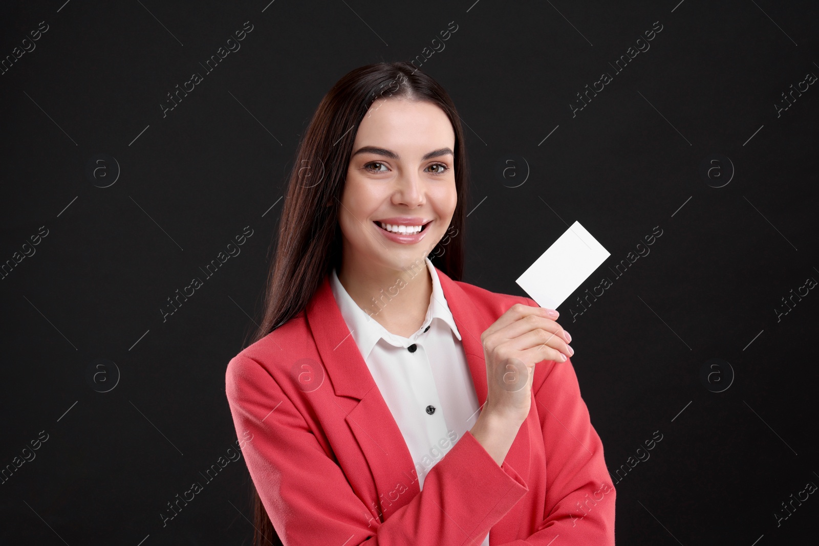 Photo of Happy woman holding blank business card on black background