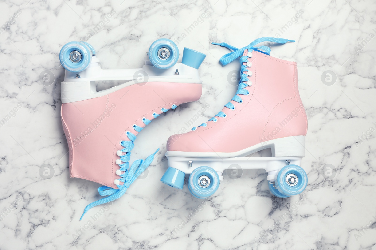 Photo of Pair of stylish quad roller skates on marble background, top view