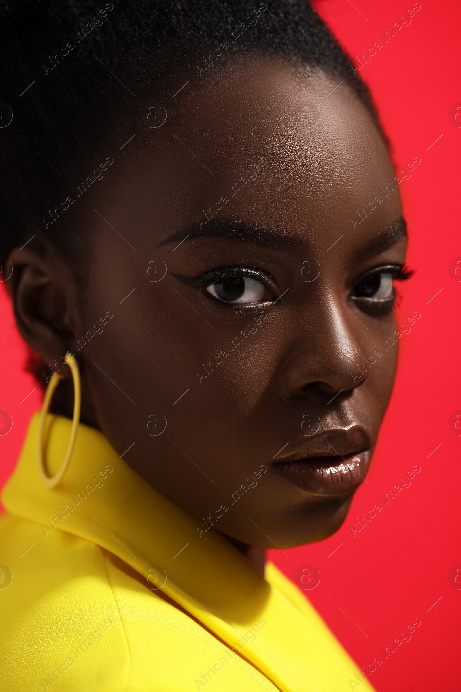 Photo of Fashionable portrait of beautiful woman on coral background, closeup