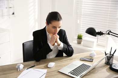 Photo of Stressed and tired young woman at workplace