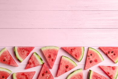 Photo of Slices of ripe watermelon on pink wooden table, flat lay. Space for text