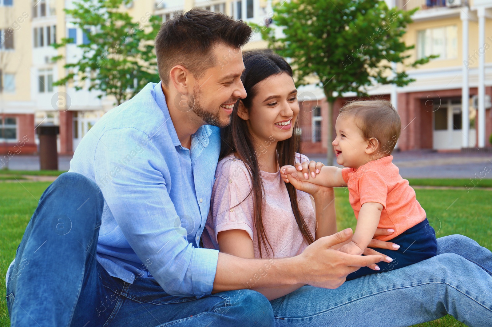 Photo of Happy family with adorable little baby outdoors