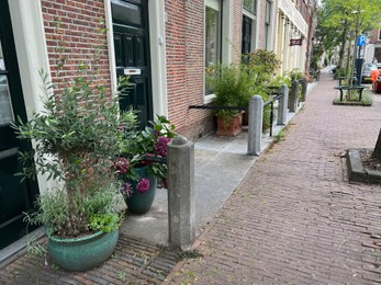 LEIDEN, NETHERLANDS - JULY 22, 2022: Beautiful view of city street with buildings and plants on sunny day