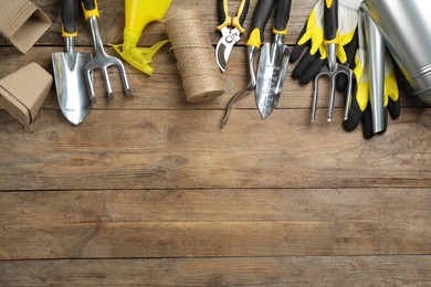 Flat lay composition with gardening tools on wooden background, space for text