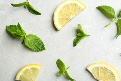 Photo of Fresh mint with sliced lemon on grey marble background, flat lay