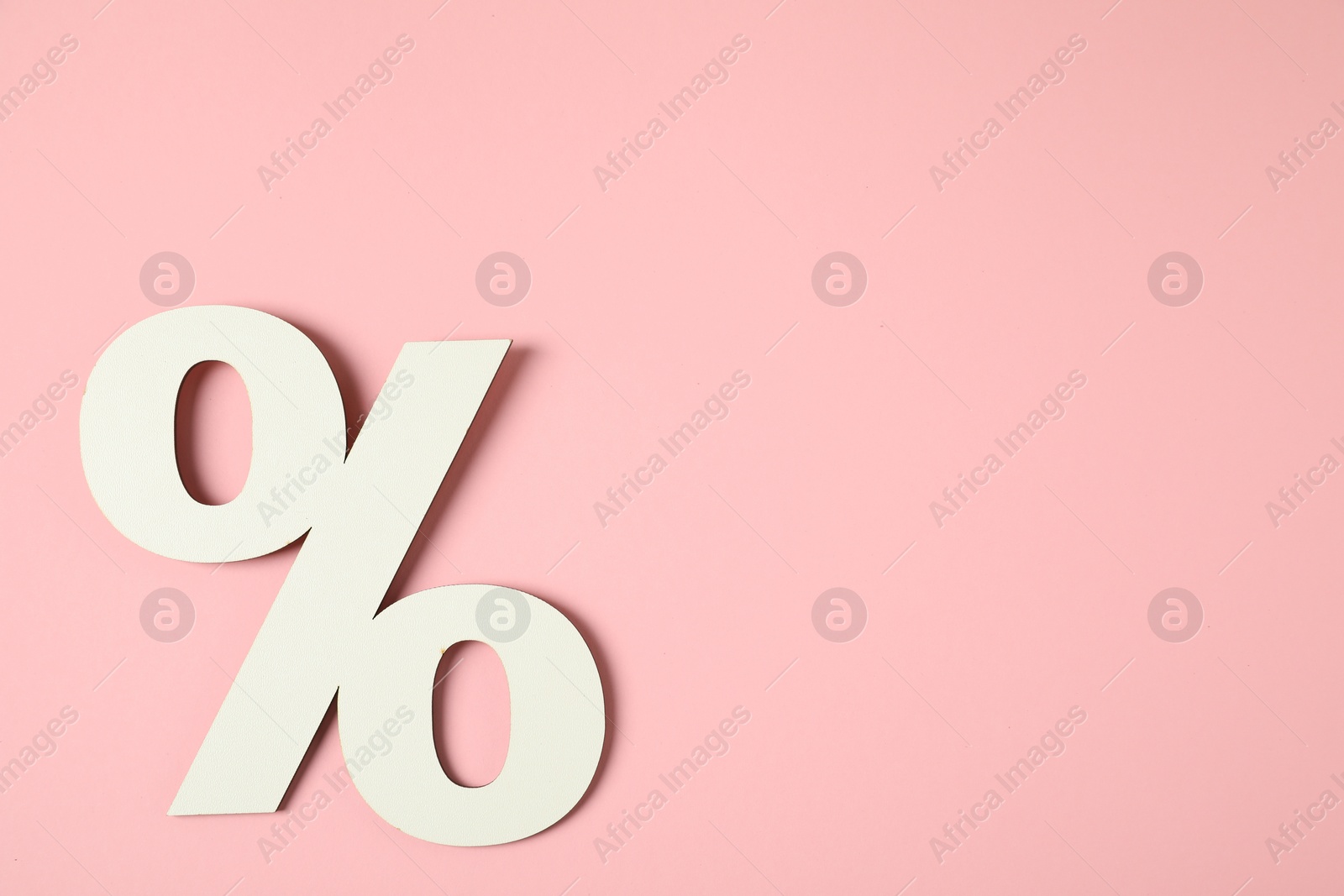 Photo of White percent sign on pink background, top view. Space for text