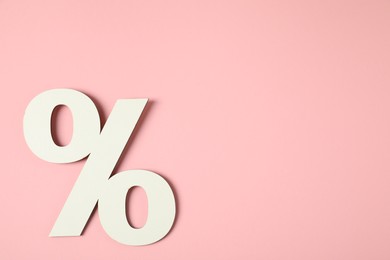 Photo of White percent sign on pink background, top view. Space for text