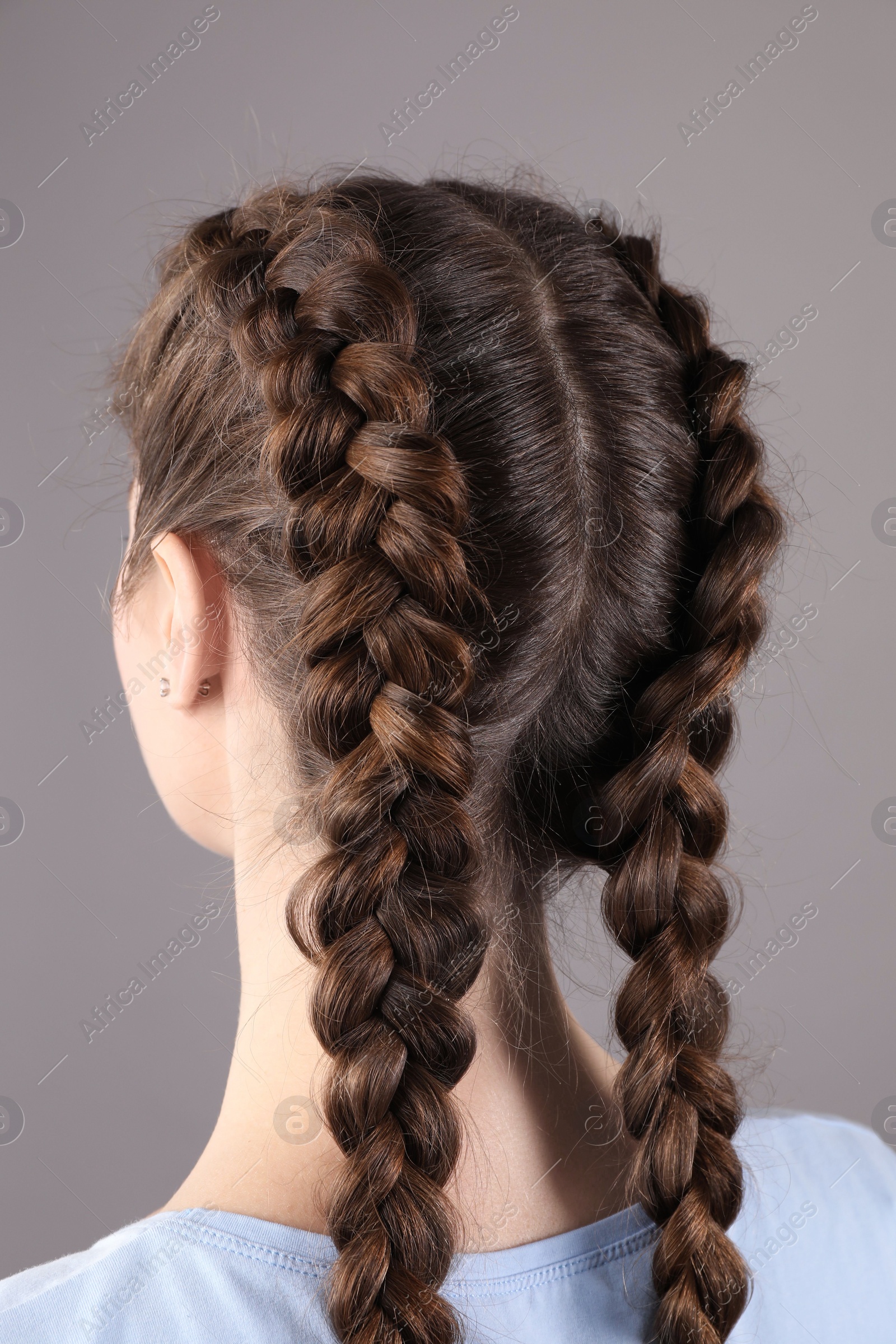 Photo of Woman with braided hair on grey background, back view