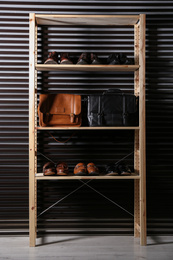Photo of Wooden shelving unit with different leather shoes and bags