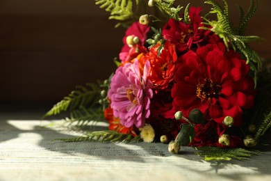 Photo of Bouquet of beautiful wild flowers on wooden rustic table against dark background. Space for text