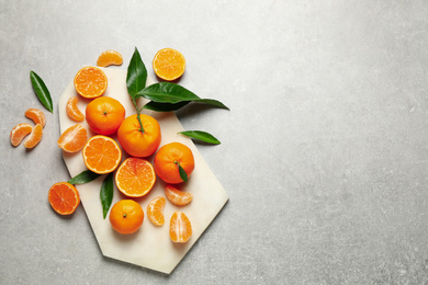 Photo of Fresh ripe tangerines and space for text on grey table, flat lay. Citrus fruit