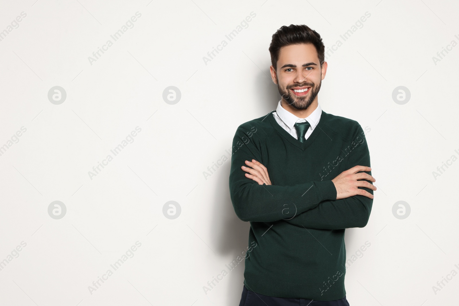 Photo of Portrait of handsome young man smiling on light background. Space for text