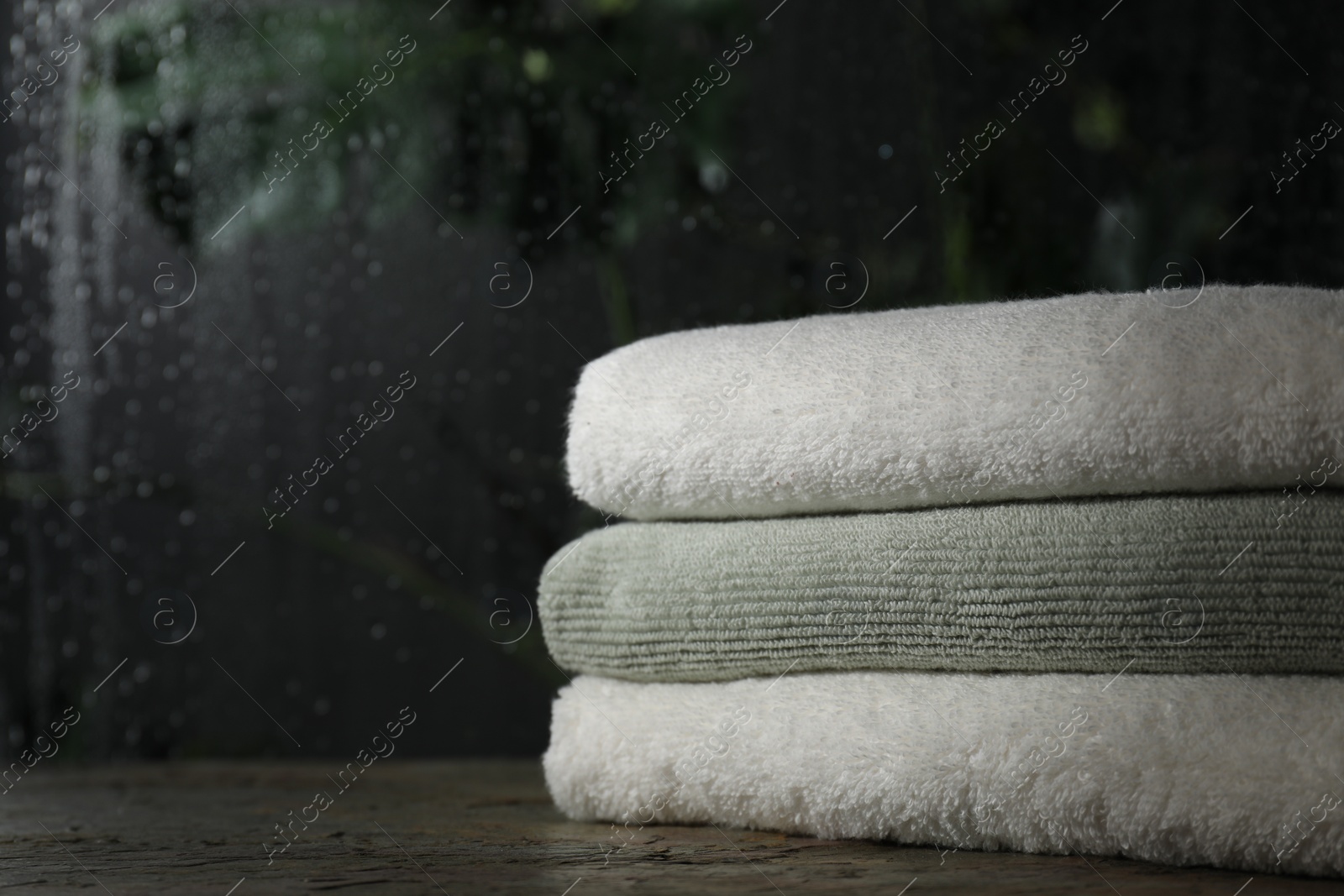 Photo of Stacked terry towels on table indoors, space for text