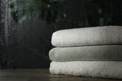 Stacked terry towels on table indoors, space for text