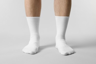 Photo of Man in stylish white socks on light grey background, closeup