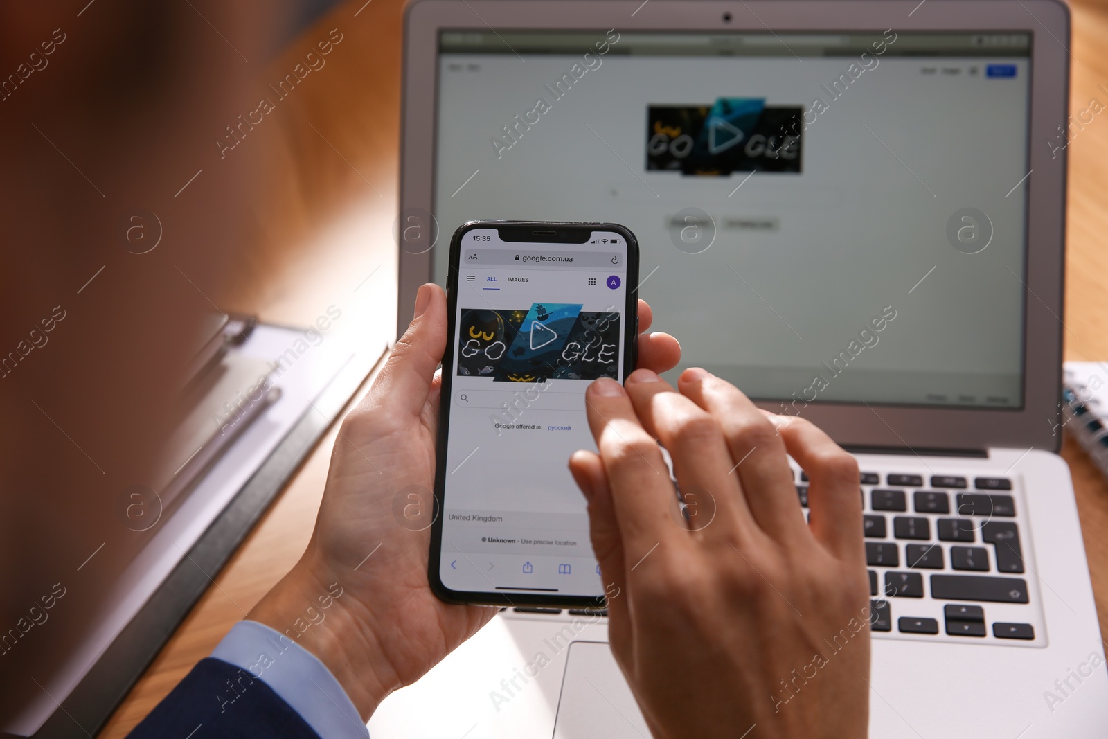 Photo of MYKOLAIV, UKRAINE - OCTOBER 31, 2020: Person using Google search engine on smartphone at table, closeup