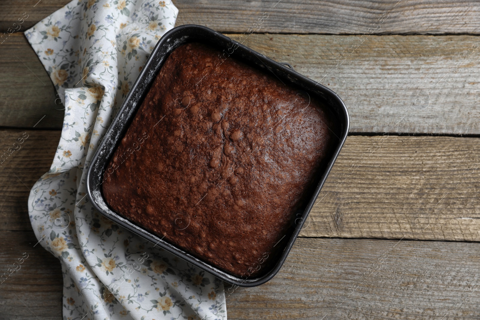 Photo of Homemade chocolate sponge cake on wooden table, top view. Space for text