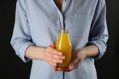 Photo of Woman holding bottle of immunity boosting drink in hands, closeup