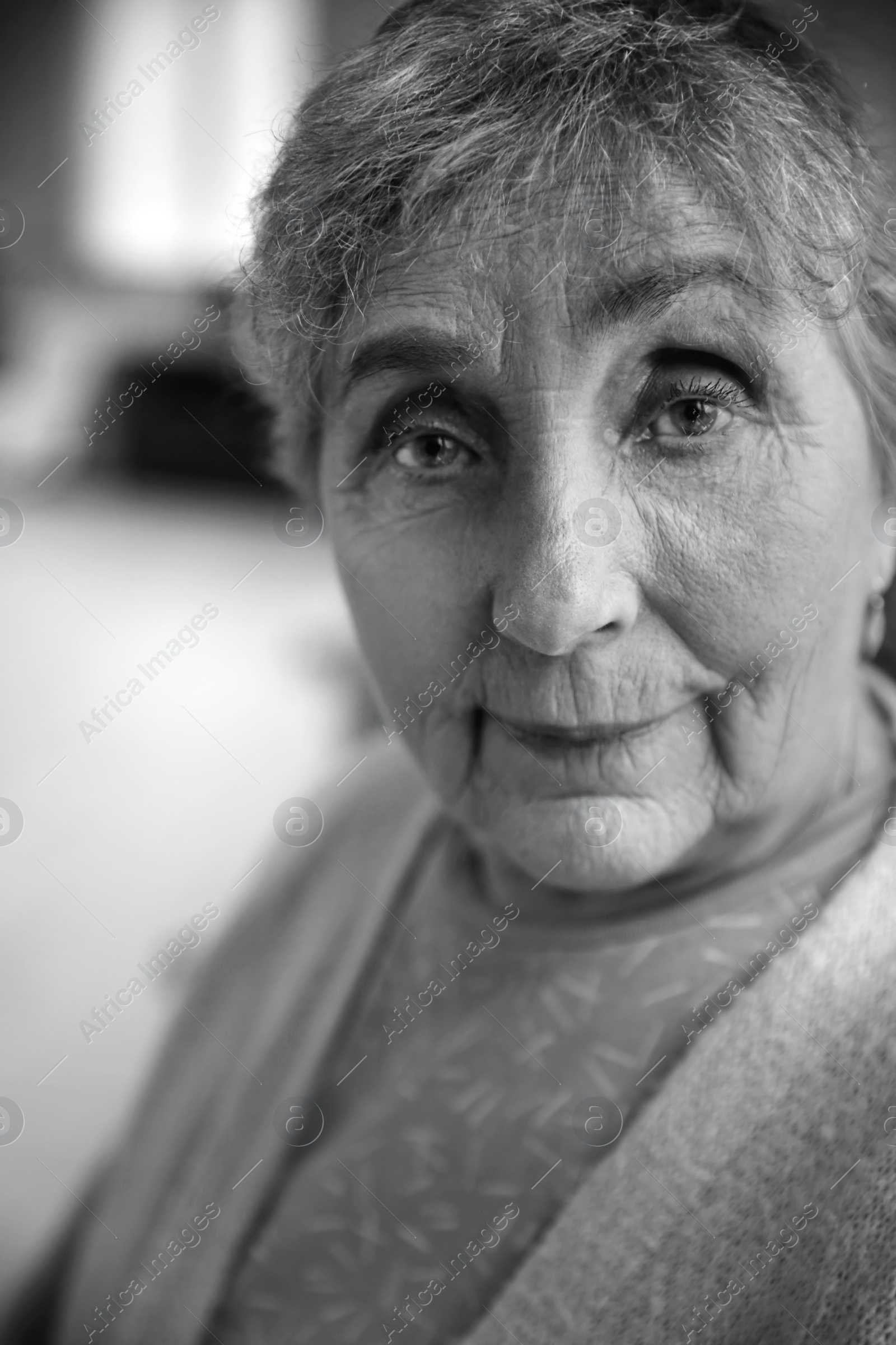 Photo of Portrait of elderly woman indoors. Black and white effect