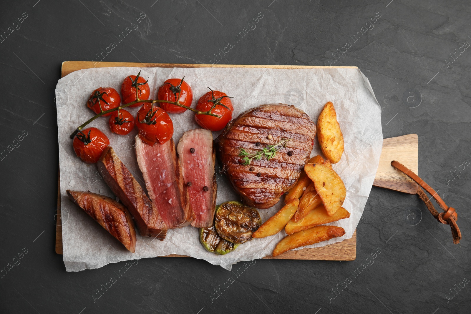 Photo of Delicious beef served on black table, top view